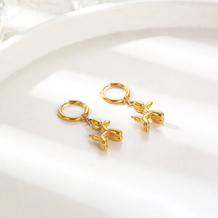 Boucles d'oreilles Huggie en or avec un pendentif en forme de mini ballon en forme de chien